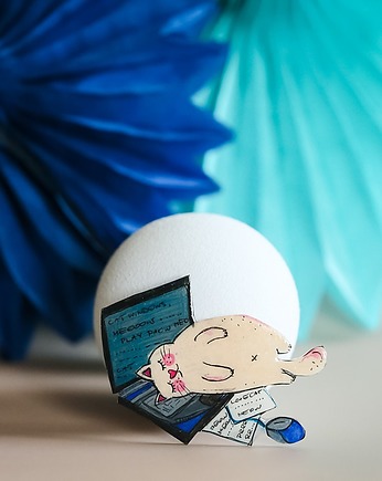 Broszka kot leżący na laptopie